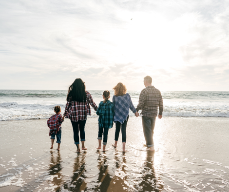 Family walking along the beach. Canada Psychotherapy provides compassionate and effective support tailored to your family's unique needs.