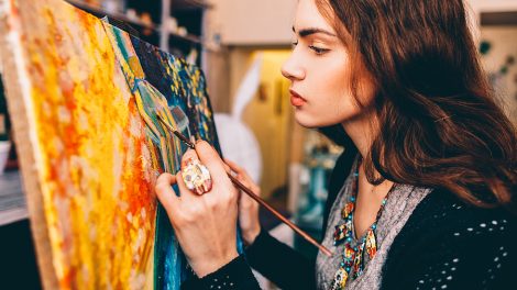 Tennager painting on a canvas. Art therapy for is a powerful tool that uses the creative process of making art to improve a child’s physical, mental, and emotional well-being.
